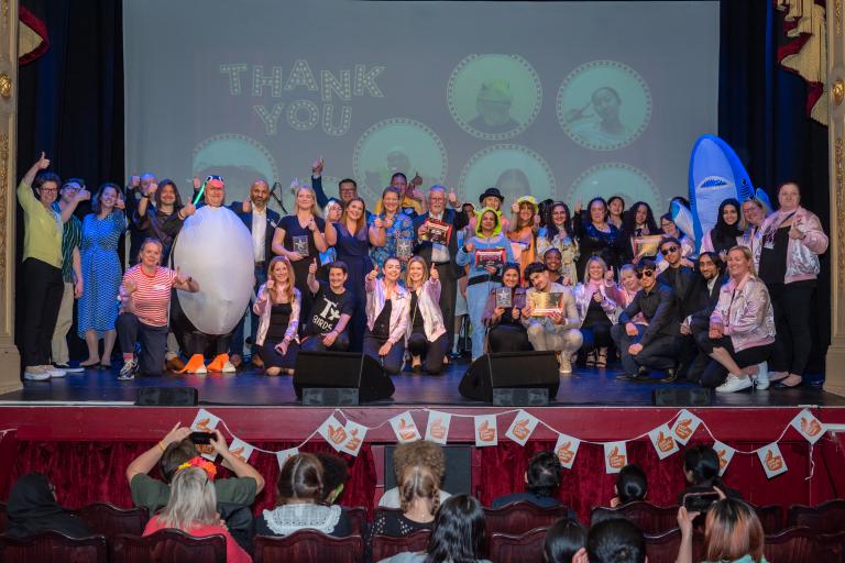 large group of people on stage at an awards show