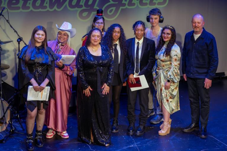 group of people standing on stage at an awards event