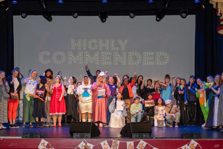 A group of several young people standing on a stage