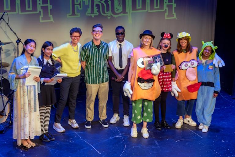 group of people standing on stage at an awards event