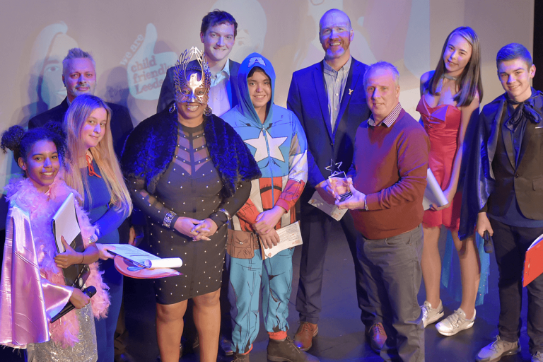 group of people standing on stage at an awards event