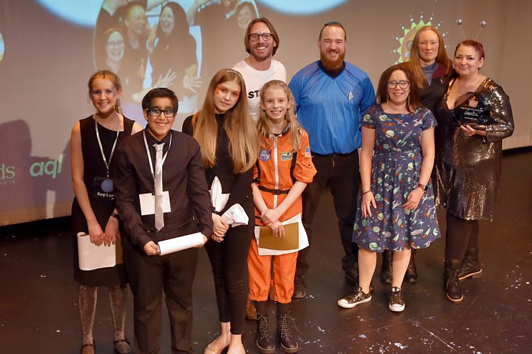 Several people posing at an awards show