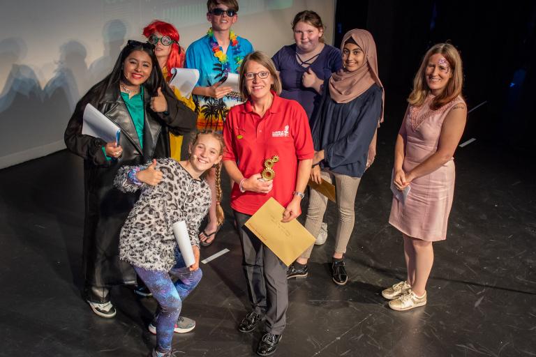 group of people standing on stage at an awards event