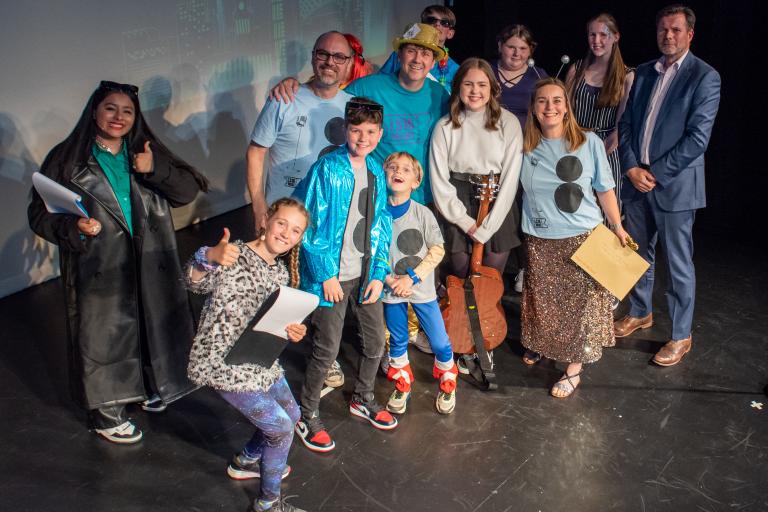 group of people standing on stage at an awards event