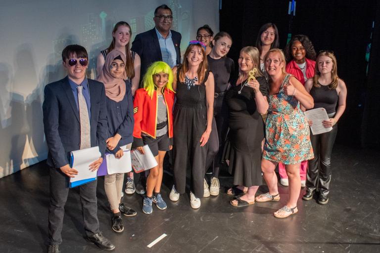 group of people standing on stage at an awards event