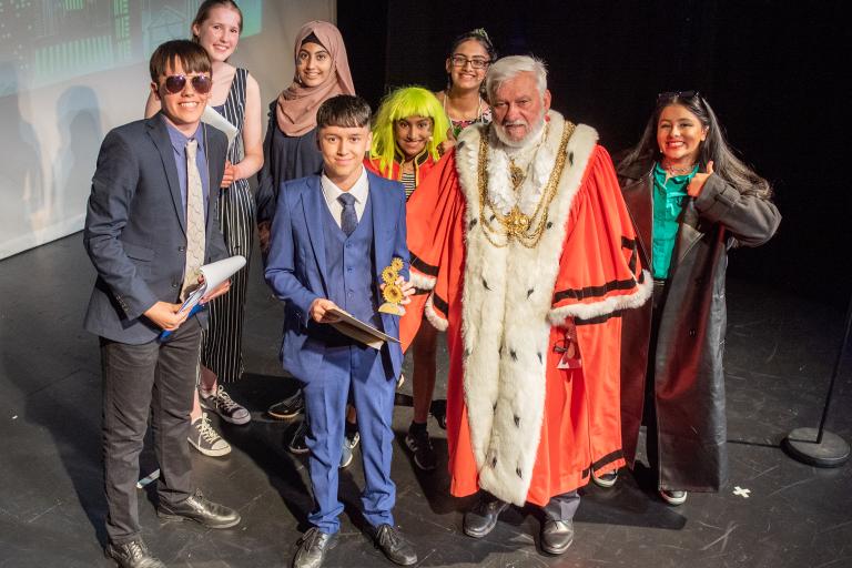 group of people standing on stage at an awards event