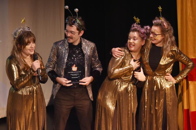 4 people on stage at an awards show