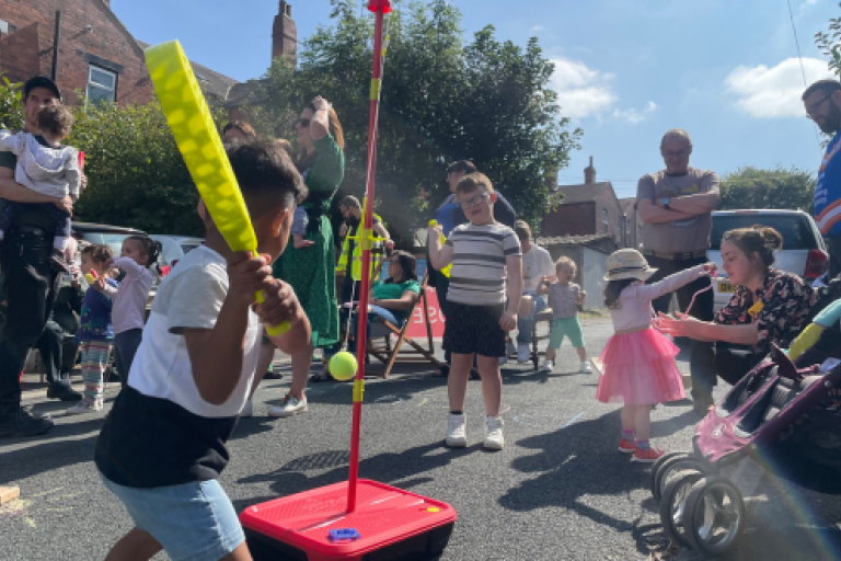 Children playing swing-ball in the street.