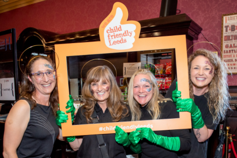 A group posing with a Child Friendly Leeds thumb frame