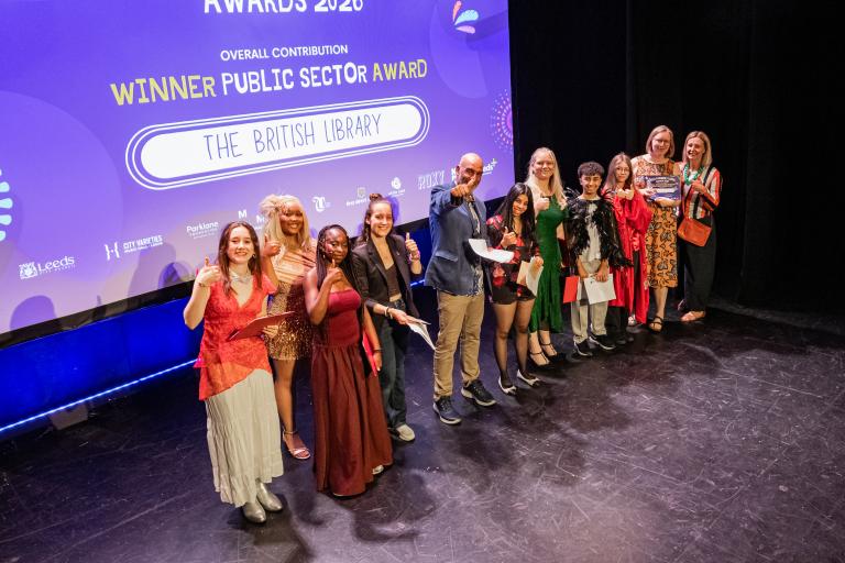 Representatives from The British Library pose on stage with an award.
